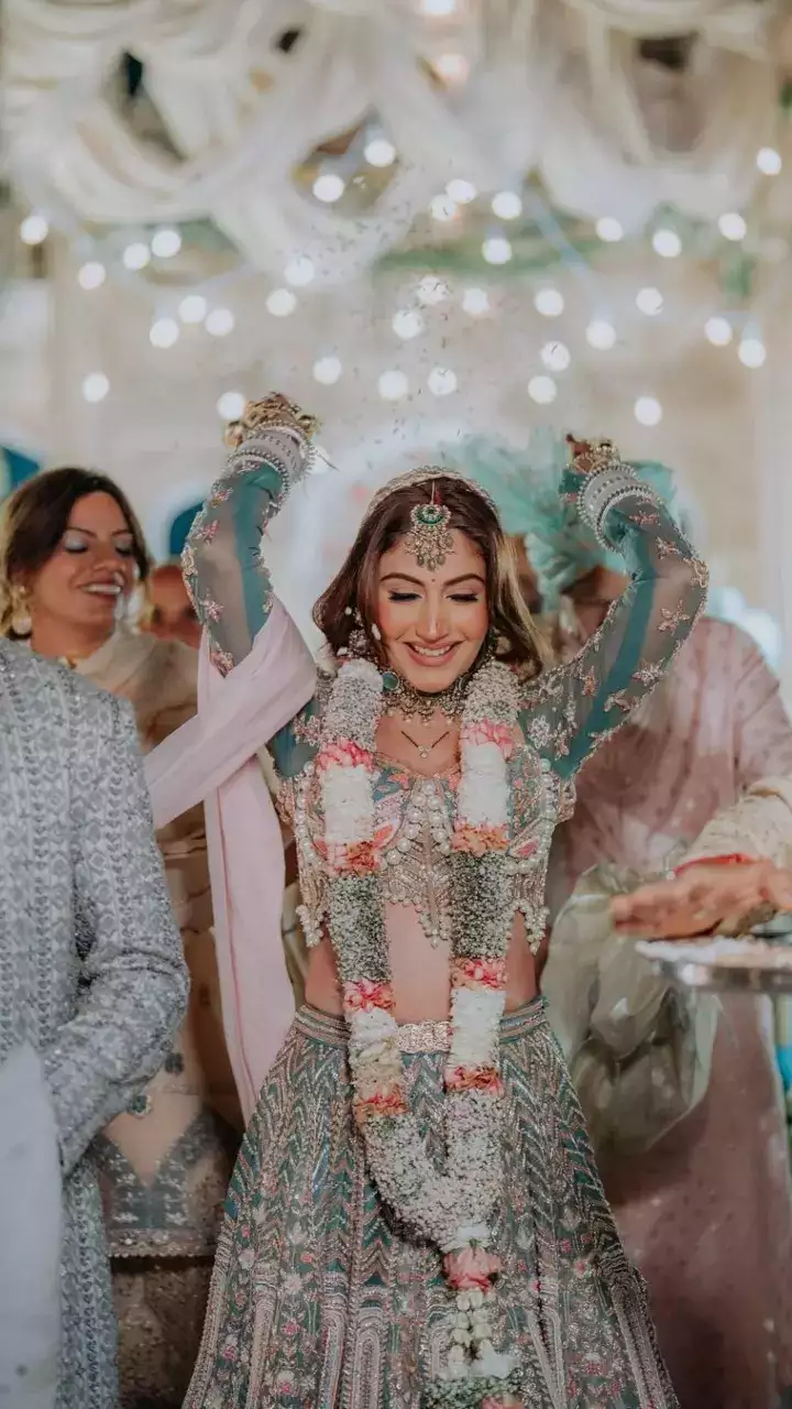 Talking about Surbhi's bridal look, she wore a full-sleeve choli which had a sweetheart neckline, a silver color and mixed baby pink color lehenga and completed her look with a baby pink color long trail dupatta.